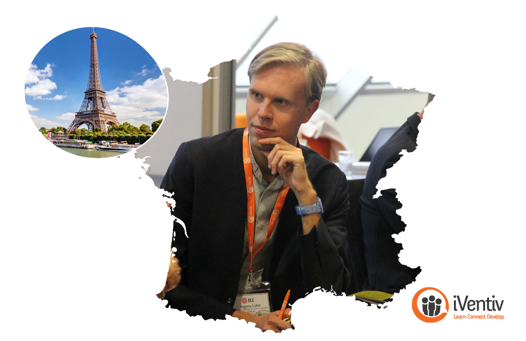 An image of Evgeny Lukin (JLL) in conversation with a peer at an iVentiv event, inside a map of France